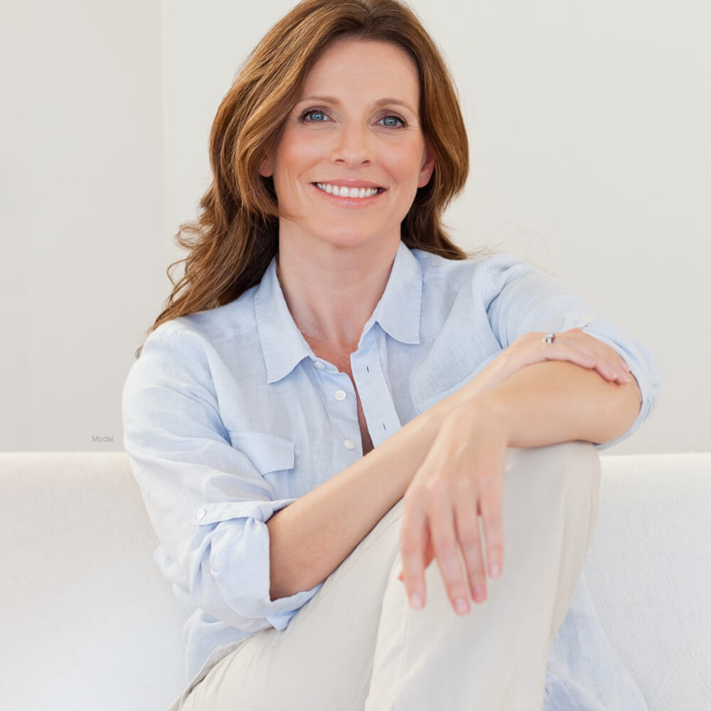 Mature woman sitting on a white couch